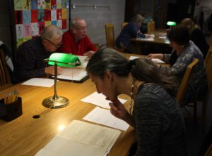 Photograph shows project staff and volunteers doing research.